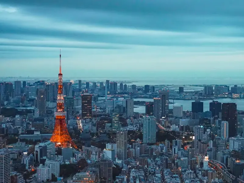Tokyo Tower lit up over the Tokyo skyline at dusk